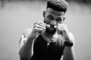 African american male athlete boxer man in sportswear doing stretching at stadium. photo