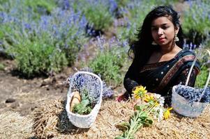 Beautiful indian girl wear saree india traditional dress in purple lavender field. photo