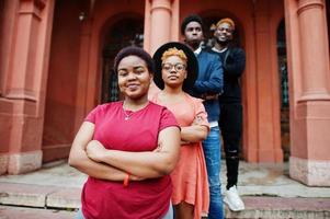 Four african friends posed outdoors against old architecture. Two black girls with guys. photo