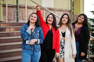 Group of four happy and pretty latino girls from Ecuador posed at street. photo