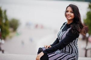 Portrait of young beautiful indian or south asian teenage girl in dress against river. photo