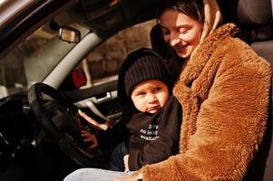 joven madre e hijo en coche. concepto de conducción segura. foto