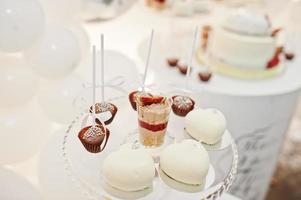 Candy bar decoration setup with delicious cakes and sweets. photo