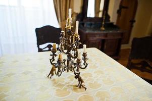 Close-up photo of sophisticated golden candelabrum on the table.