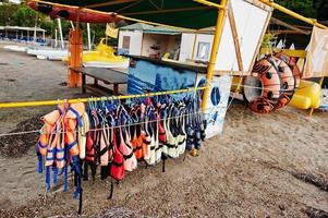 Life vests ready to use for water sports at sand beach. photo