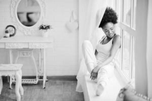 Young african american woman in pink singlet against window. Perfect morning. photo