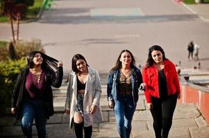 Group of four happy and pretty latino girls from Ecuador posed at street. photo