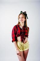 joven ama de casa divertida en camisa a cuadros y pantalones cortos amarillos pin up estilo aislado sobre fondo blanco. foto