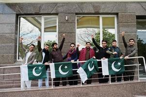 grupo de hombres paquistaníes vestidos con ropa tradicional salwar kameez o kurta con banderas de pakistán. foto