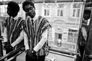 hombre africano con ropa tradicional y gafas en elavator o ascensor moderno. foto