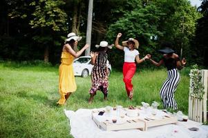 grupo de chicas afroamericanas celebrando la fiesta de cumpleaños divirtiéndose y bailando al aire libre con decoración. foto