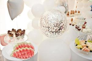 Candy bar decoration setup with delicious cakes and sweets. photo