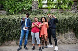 Four african friends having fun outdoors. Two black girls with guys. photo