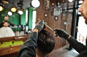 apuesto hombre barbudo en la barbería, peluquero en el trabajo. foto