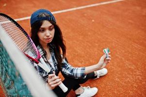 Young sporty girl player with tennis racket on tennis court. photo