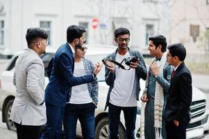 Group of six south asian indian mans in traditional, casual and business wear. Asia tourists looking at the dslr photo camera.