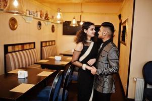 Lovely indian couple in love, wear at saree and elegant suit, posed on restaurant. photo