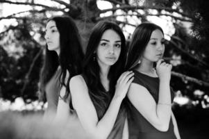 Three teenagers girl in blue and red dresses posed outdoor. photo