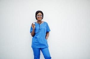 retrato de una feliz pediatra joven afroamericana con uniforme azul y estetoscopio aislado en blanco. cuidado de la salud, médico, especialista en medicina - concepto. foto