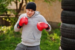 Man arabian boxer in hat training for a hard fight outdoor gym. photo