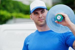 Delivery man in front cargo van delivering bottles of water. photo