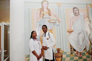 dos estudiantes de doctores afroamericanos en bata de laboratorio con estetoscopio dentro de la universidad médica. foto