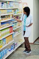 African american pharmacist working in drugstore at hospital pharmacy. African healthcare. photo