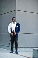 Handsome fashionable african american man in formal wear and bow tie with walking stick. photo