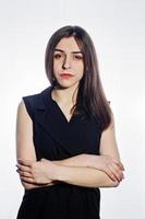 Close-up emotional portrait of a brunette girl in black jumpsuit on white background. photo