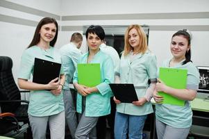 Medical theme.Observation room with a computer tomograph. The group of female doctors with clipboards meeting in the mri office at diagnostic center in hospital. photo