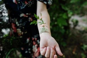 foto de primer plano de una flor pegada al brazo de una mujer.