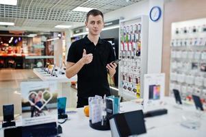 Seller man mobile phone professional consultant in tech store or shop. photo