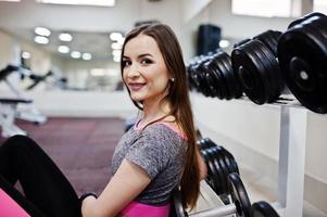 joven morena sexy chica delgada haciendo ejercicio en el gimnasio. foto