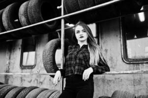 Young hipster girl in checkered shirt at tire fitting zone. photo