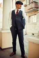 Portrait of retro 1920s english arabian business man wearing dark suit, tie and flat cap. photo