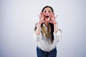 Portrait of a young woman in blouse and blue trousers screaming. photo