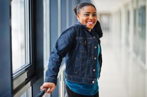 African woman in jeans jacket posed indoor. photo