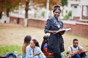 Group of five african college students spending time together on campus at university yard. Black afro friends studying. Education theme. photo