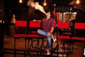 Asian man smoke hookah and having rest at lounge bar. photo