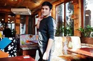 Stylish indian man in casual wear posing indoor cafe. photo