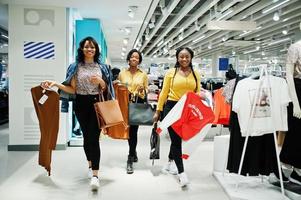 Three african woman choosing clothes at store. Shopping day. photo