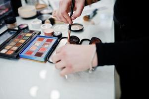 Many brushes on a table in the salon. Workplace makeup artist. Set of brushes for makeup. photo