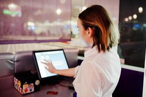 Waiter girl working with pos terminal or cashbox at cafe. People and service concept photo