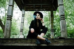 Sensual smoker girl all in black, red lips and hat. Goth dramatic woman smoking thin cigarette. photo