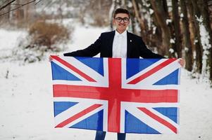 hombre indio con estilo en traje con bandera de gran bretaña posada en el día de invierno al aire libre. foto