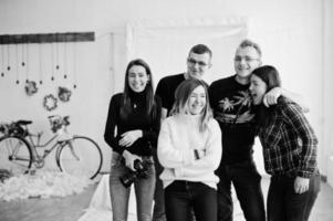 Group of five peoples, friends photographers and designers on studio shooting after hard work day. They happy and laughing. photo