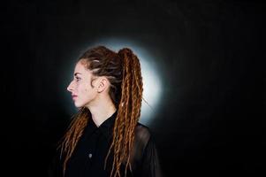 Studio shoot of girl in black with dreads at black background with nimbus. photo