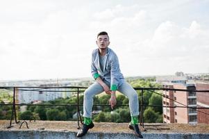 hombre macho con estilo soñador en traje gris y gafas posadas en el techo. foto