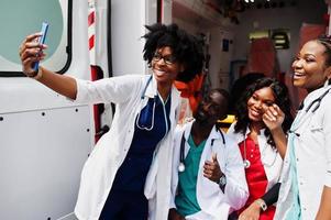 Group of african paramedic ambulance emergency crew doctors making selfie on phone. photo