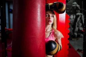 Sexy sport blonde girl punching bag. Fit woman boxing. photo